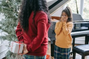Get Your Christmas Script Seen. African-American mom and daugther with gift.